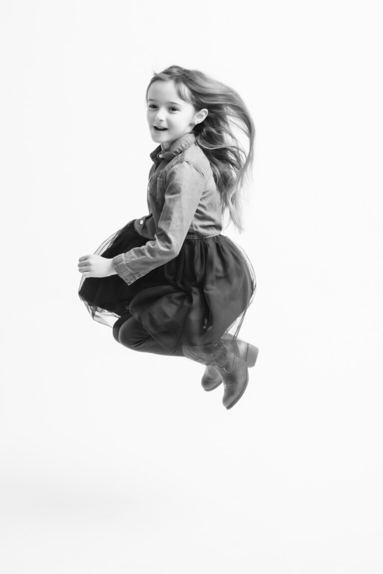 black and white family portraits little girl jumping